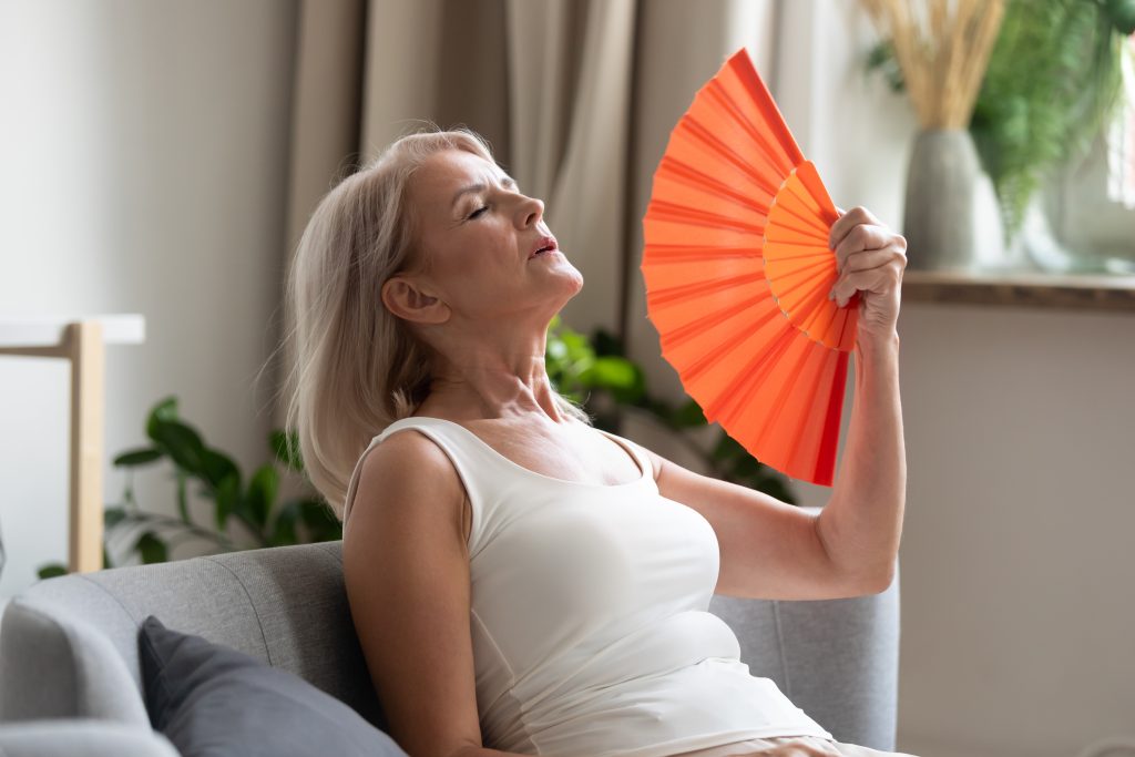 woman fanning herself | menopause and topical estrogen