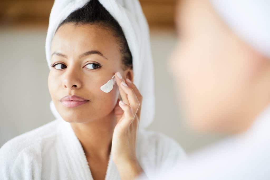 woman applying lotion | skincare routine