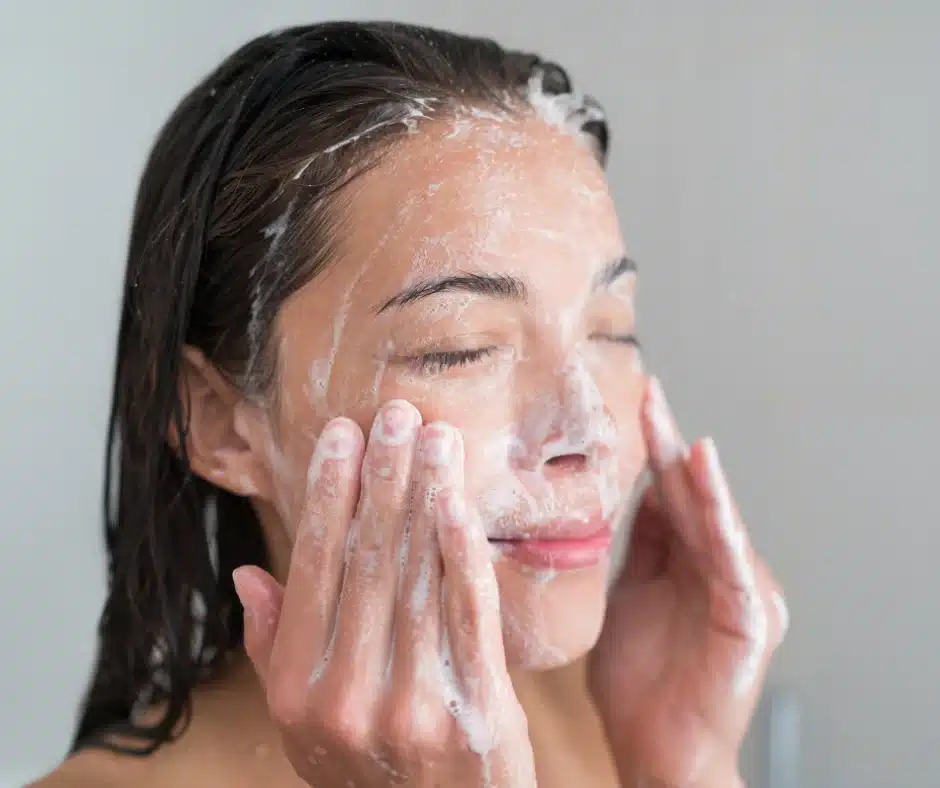 little bumps on forehead: woman using anti dandruff shampoo for face